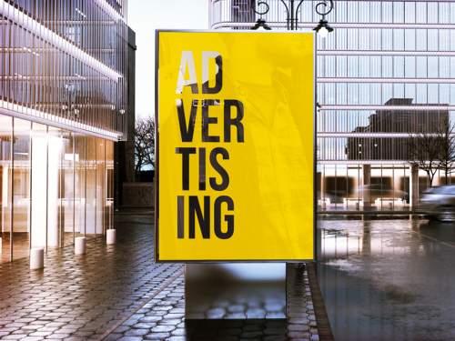 Affiche jaune ADVERTISING posÃ©e sur un panneau d'affichage extÃ©rieur sur un trottoir