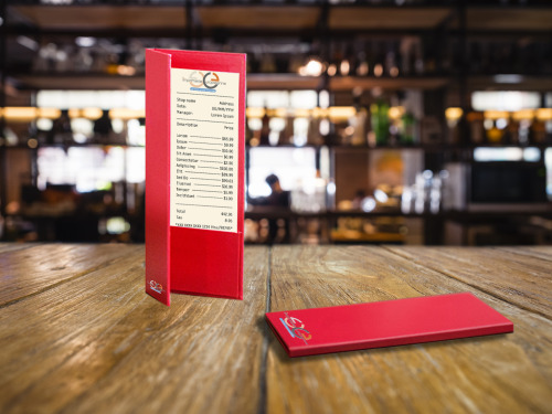Porte addition rouge posé sur une table en bois